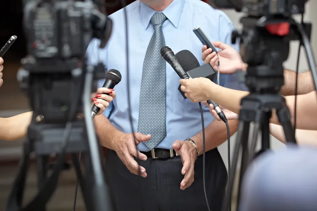 Man being interviewed by news cameras